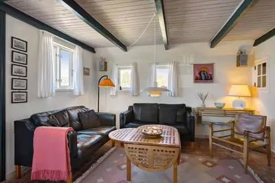 a living room with a leather couch and a table at BL1449-Blokhus-Kienersvej-8 in Blokhus