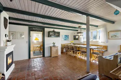 a living room with a fireplace and a dining room at BL1449-Blokhus-Kienersvej-8 in Blokhus