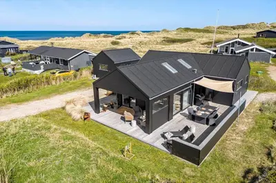 an overhead view of a black house on a beach at BL1427-Blokhus-Ovesensvej-9 in Blokhus