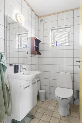 a white bathroom with a toilet and a sink at BL137-Blokhus-Pirupshvarre-Klit-6 in Blokhus