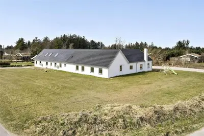 a large white house with a large grass field at BL1169-Blokhus-Berberisvej-5 in Blokhus