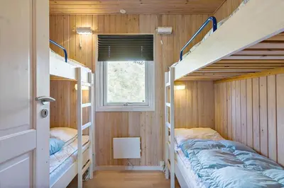 a room with two bunk beds and a window at BL1502-Blokhus-Graevlingevej-3 in Blokhus