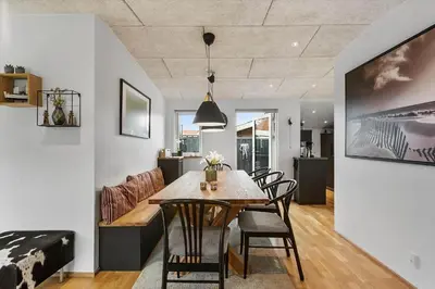 a dining room and living room with a table and chairs at BL1515-Blokhus-Peder-Madsensvej-14 in Blokhus