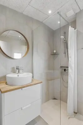 a bathroom with a sink and a shower with a mirror at BL1515-Blokhus-Peder-Madsensvej-14 in Blokhus