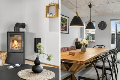 a living room with a table and a fireplace at BL1515-Blokhus-Peder-Madsensvej-14 in Blokhus