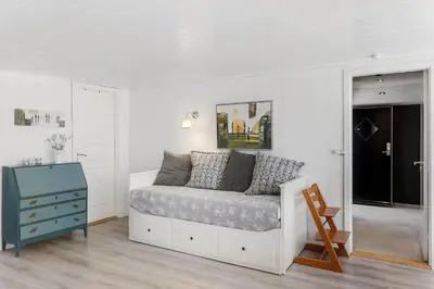 a white bedroom with a bed and a blue dresser at BL1496-Blokhus-Peder-Madsensvej-28 in Blokhus