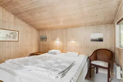 a bedroom with a bed in a room with wooden walls at BL721-Pandrup-Rodhus-Skolevej-32 in Pandrup