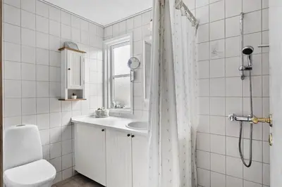 a white bathroom with a sink and a shower at BL1556-Blokhus-Poppelvej-1 in Blokhus