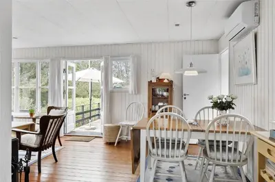 a kitchen and dining room with a table and chairs at BL1556-Blokhus-Poppelvej-1 in Blokhus