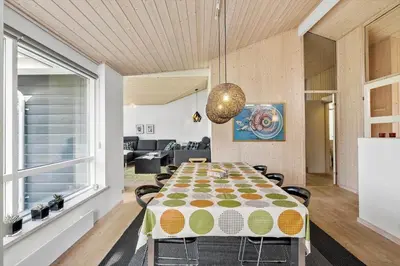 a dining room with a table and a couch at BL325-Blokhus-Lyngvej-11 in Blokhus