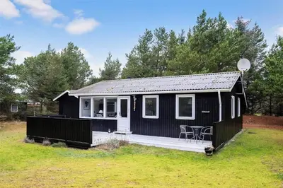 a black tiny house with a porch and a deck at BL488-Pandrup-Akelejevej-10 in Pandrup