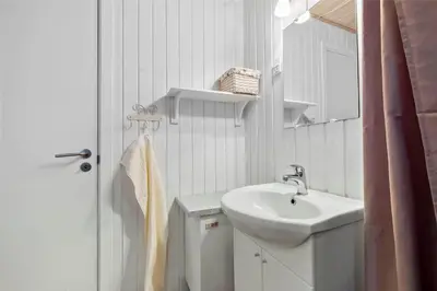 a white bathroom with a sink and a mirror at BL488-Pandrup-Akelejevej-10 in Pandrup
