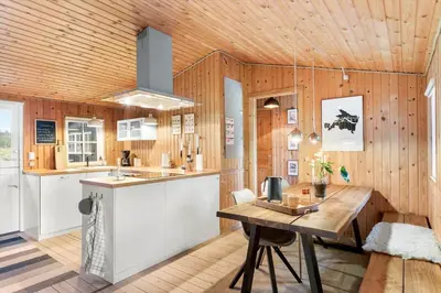 a kitchen with a wooden ceiling and a wooden table at BL1437-Blokhus-Berberisvej-78 in Blokhus
