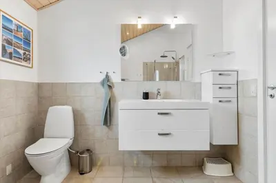 a white bathroom with a toilet and a sink at BL127-Saltum-Laustvej-22 in Saltum
