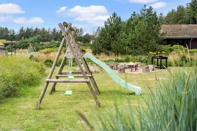 a wooden ladder with a slide in a yard at BL127-Saltum-Laustvej-22 in Saltum