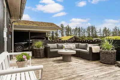 a patio with a couch and a table on a deck at BL127-Saltum-Laustvej-22 in Saltum