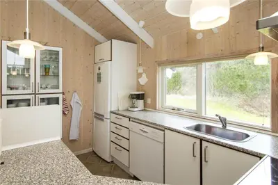 a kitchen with a sink and a refrigerator at BL481-Pandrup-Rodhusparken-10 in Pandrup