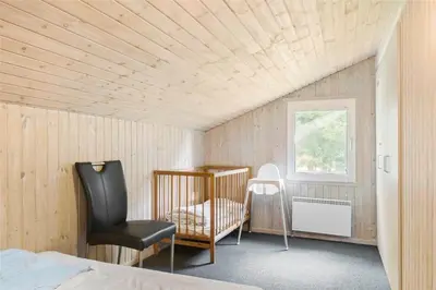 a bedroom with a bed and a chair and a window at BL714-Saltum-Ornebjergvej-24 in Saltum