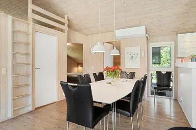 a dining room with a table and black chairs at BL714-Saltum-Ornebjergvej-24 in Saltum