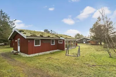 a small red house with a grass roof at BL1682-Pandrup-Rodhus-Skolevej-24 in Pandrup