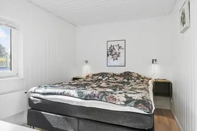 a bedroom with a bed in a white room at BL1216-Blokhus-Gyvelvej-13 in Blokhus