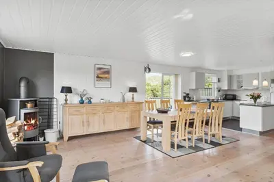 a kitchen and living room with a table and chairs at BL1216-Blokhus-Gyvelvej-13 in Blokhus
