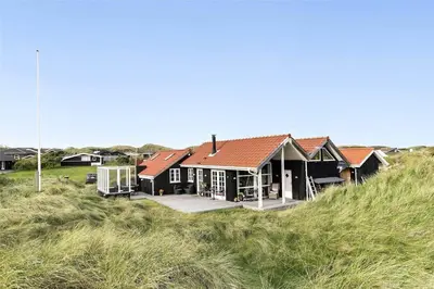 a house on the side of a sand hill at BL964-Blokhus-Klitvejen-28 in Blokhus