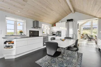 a kitchen with a table and chairs in a room at BL964-Blokhus-Klitvejen-28 in Blokhus
