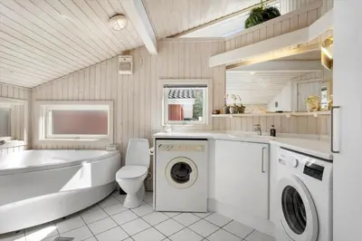 a bathroom with a tub sink and a washing machine at BL1600-Saltum-Daadyrvej-25-A in Saltum