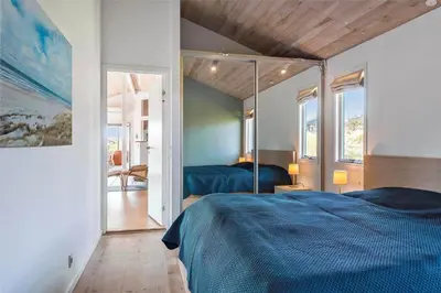 a bedroom with a blue bed and a mirror at BL188-Saltum-Kordalssletten-3 in Saltum