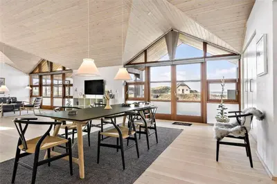 a living room with a dining room table and chairs at BL1733-Blokhus-Dahl-Iversensvej-5 in Blokhus