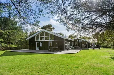 a large black house with a large yard at BL226-Blokhus-Paa-Bakken-13 in Blokhus