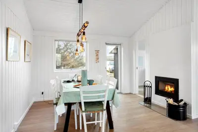 a dining room with a table and a fireplace at BL332-Saltum-Svendborgvej-18 in Saltum
