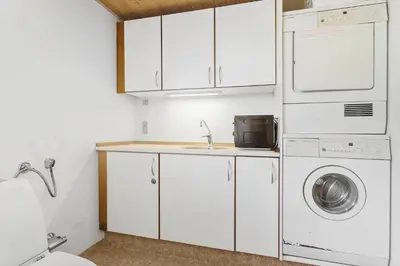 a kitchen with a washer and dryer and a sink at BL789-Blokhus-Pirupshvarrevej-20 in Blokhus