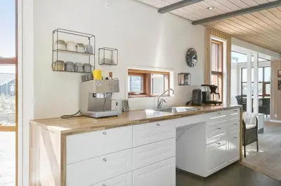 a kitchen with white cabinets and a counter top at BL789-Blokhus-Pirupshvarrevej-20 in Blokhus