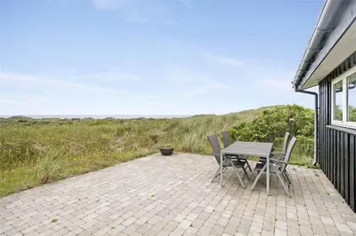 a patio with a table and chairs on the side of a house at BL216-Saltum-Svendborgvej-25 in Saltum