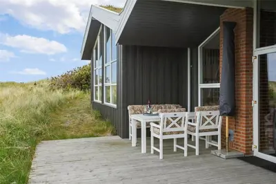 a table and chairs on the porch of a house at BL1281-Saltum-Foraarsvangen-8 in Saltum