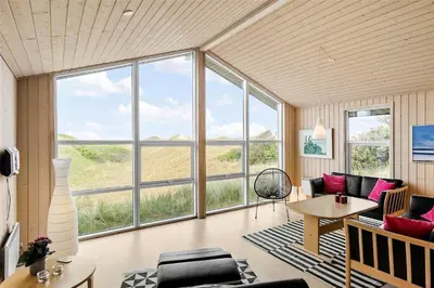 a living room with large windows and a table at BL1281-Saltum-Foraarsvangen-8 in Saltum