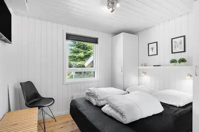 a bedroom with a bed and a chair and a window at BL257-Pandrup-Rodhus-Skolevej-44 in Pandrup