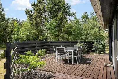 a patio with a table and chairs on a deck at BL257-Pandrup-Rodhus-Skolevej-44 in Pandrup