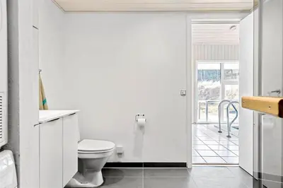 a white bathroom with a toilet and a window at BL119-Blokhus-Egebaeksvej-20 in Blokhus