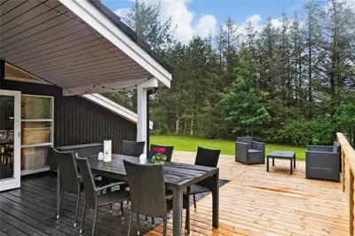 a patio with a table and chairs on a deck at BL762-Blokhus-Berberisvej-49 in Blokhus