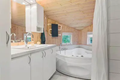 a bathroom with a tub and a sink and a bath tub at BL762-Blokhus-Berberisvej-49 in Blokhus
