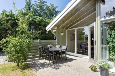 a table and chairs on a patio outside of a house at BL609-Pandrup-Rodhus-Skolevej-10 in Pandrup