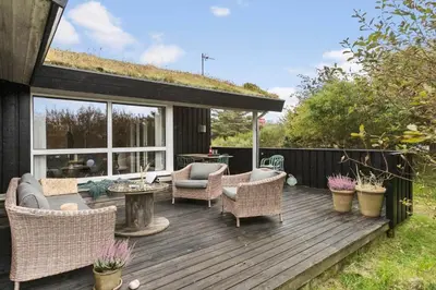 a wooden deck with wicker chairs and a table at BL1227-Saltum-Porsevej-31 in Saltum