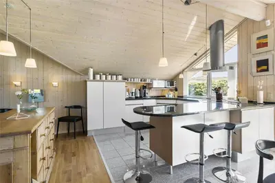 a kitchen with white cabinets and black bar stools at BL201-Saltum-Kalundborgvej-21 in Saltum