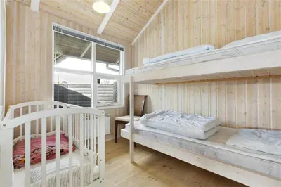 a bedroom with two bunk beds and a window at BL637-Blokhus-Klitvejen-35 in Blokhus