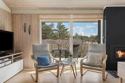a living room with two chairs and a fireplace at BL103-Saltum-Daadyrvej-23-A in Saltum