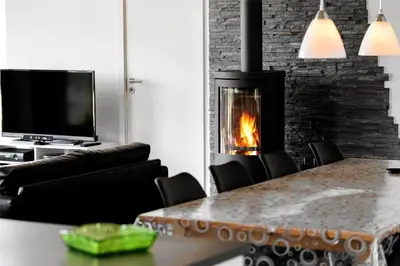a living room with a table and a fireplace at BL417-Blokhus-Saetergaardsstien-6-A in Blokhus
