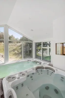 a hot tub in a room with windows at BL1777-Blokhus-Lyngbakkevej-10 in Blokhus